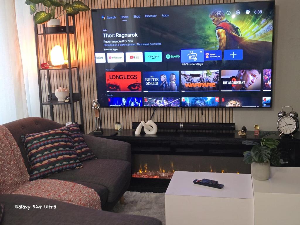 a living room with a couch and a large screen at Simple entire apartment 2 bedroom night rest in Kitchener