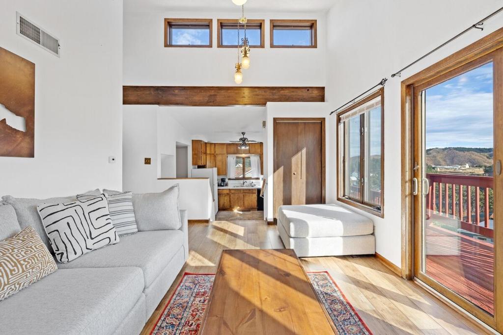 a living room with a couch and a kitchen at Lead Haven Lodge in Lead