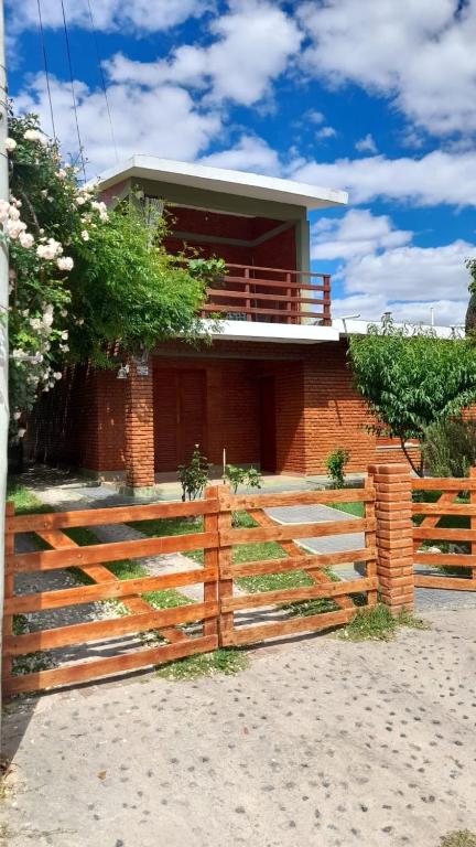 une maison avec une clôture en bois devant dans l'établissement La casa del pino, à Mina Clavero