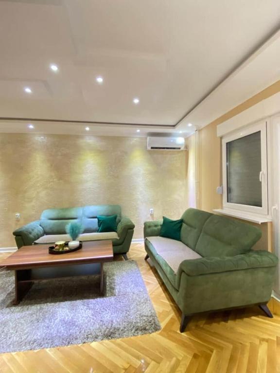 a living room with a green couch and a coffee table at Rustic Elegance Suite in Vrbas