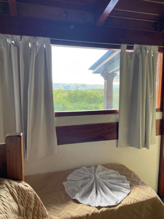 une chambre avec une fenêtre et un lit avec un oreiller dans l'établissement Casa Villa Icho Cruz, à Villa Icho Cruz