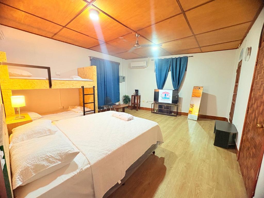 a bedroom with a bed and a tv in it at Casa Azucena in Flores