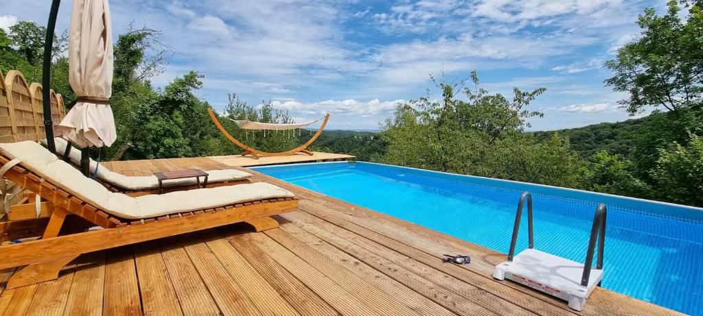 a pool with chairs and a hammock on a wooden deck at Chalet Vito - Where Luxury Meets Tranquility in Gregurić Breg