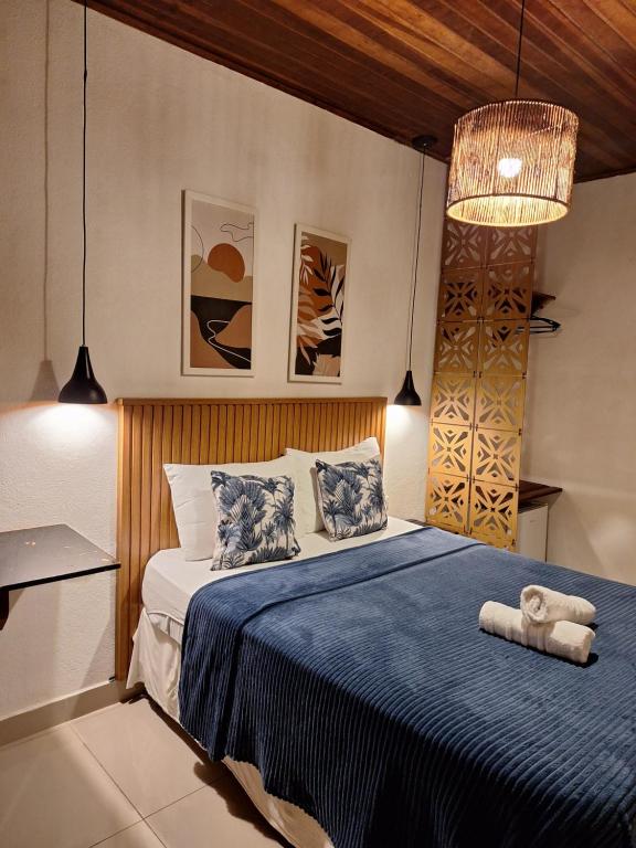 a bedroom with a bed with a blue comforter at Pousada Schueng in Trindade