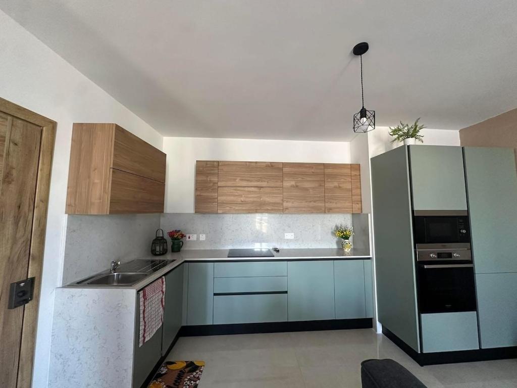 a kitchen with a sink and a refrigerator at PrimeRose Penthouse in Sannat