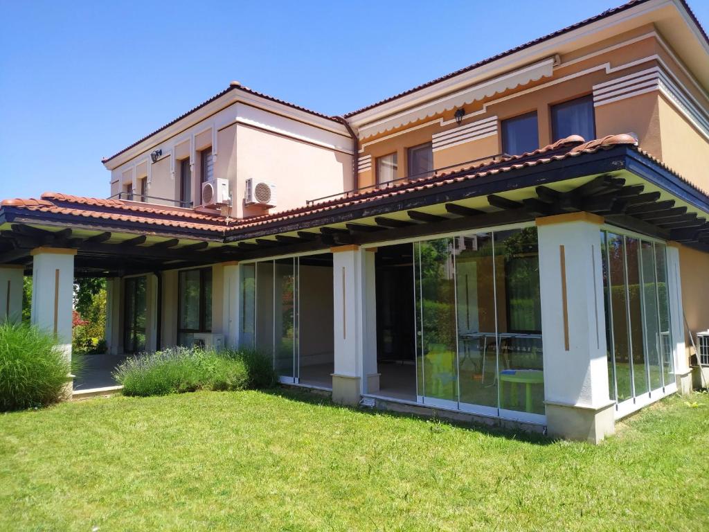 a house with glass doors on a lawn at Green Line Villa Sozopol in Sozopol