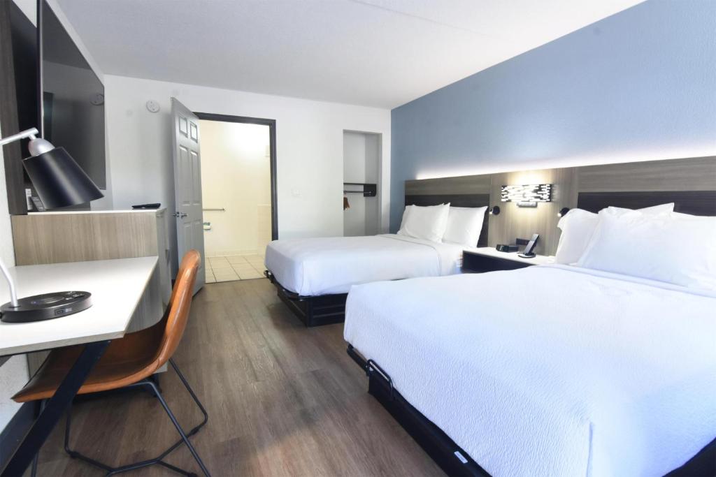 a hotel room with two beds and a desk at Best Western Point South in Yemassee