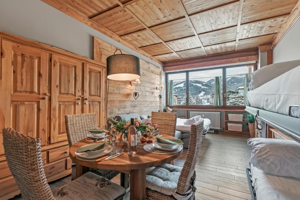 een eetkamer met een tafel en stoelen bij Studio Charming Sportinia - Happy Rentals in Sauze d'Oulx