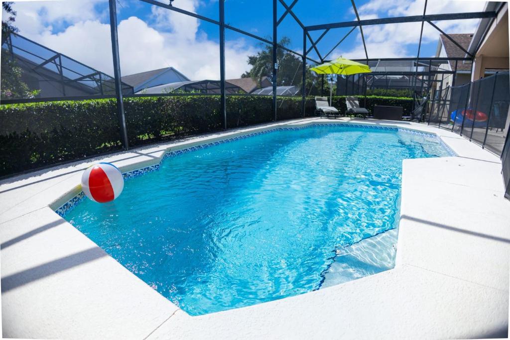 a swimming pool with a ball and an umbrella at Casa Kissimmee in Orlando
