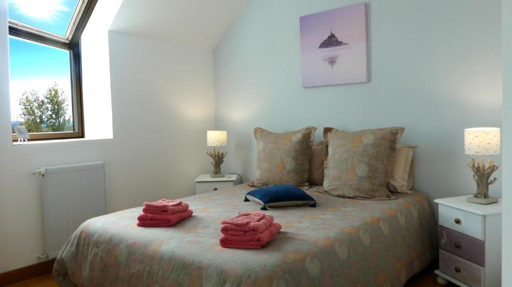 a bedroom with a bed with two towels on it at Séjour Bien-Être et Saveurs Bio, au calme avec vue sur la vallée, près du Mont Saint Michel in Braffais