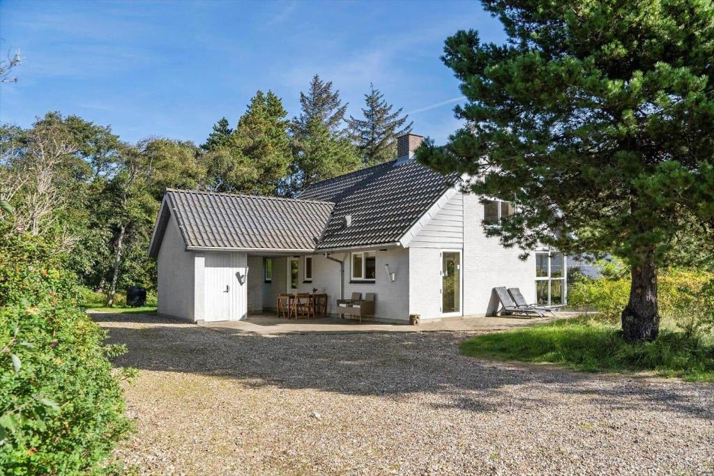 een wit huis met een veranda en een boom bij 852-Bedsted-Thy-Istrupvej-35 in Stenbjerg