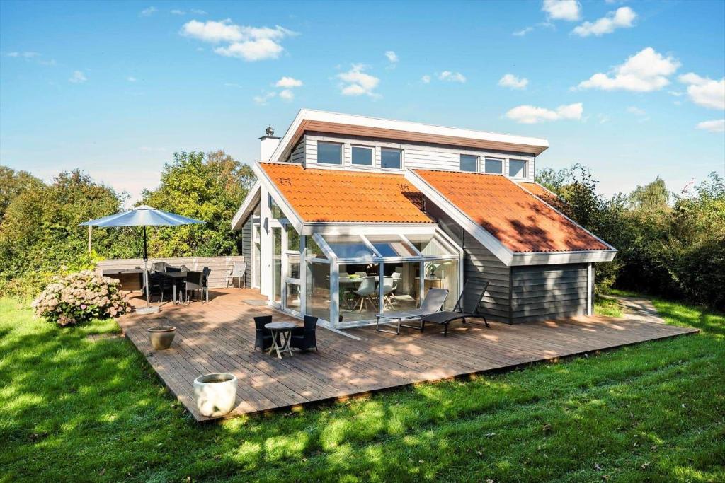 a house with an orange roof on a wooden deck at N334-Karrebaeksminde-Reedtzholmvej-127 in Enø By