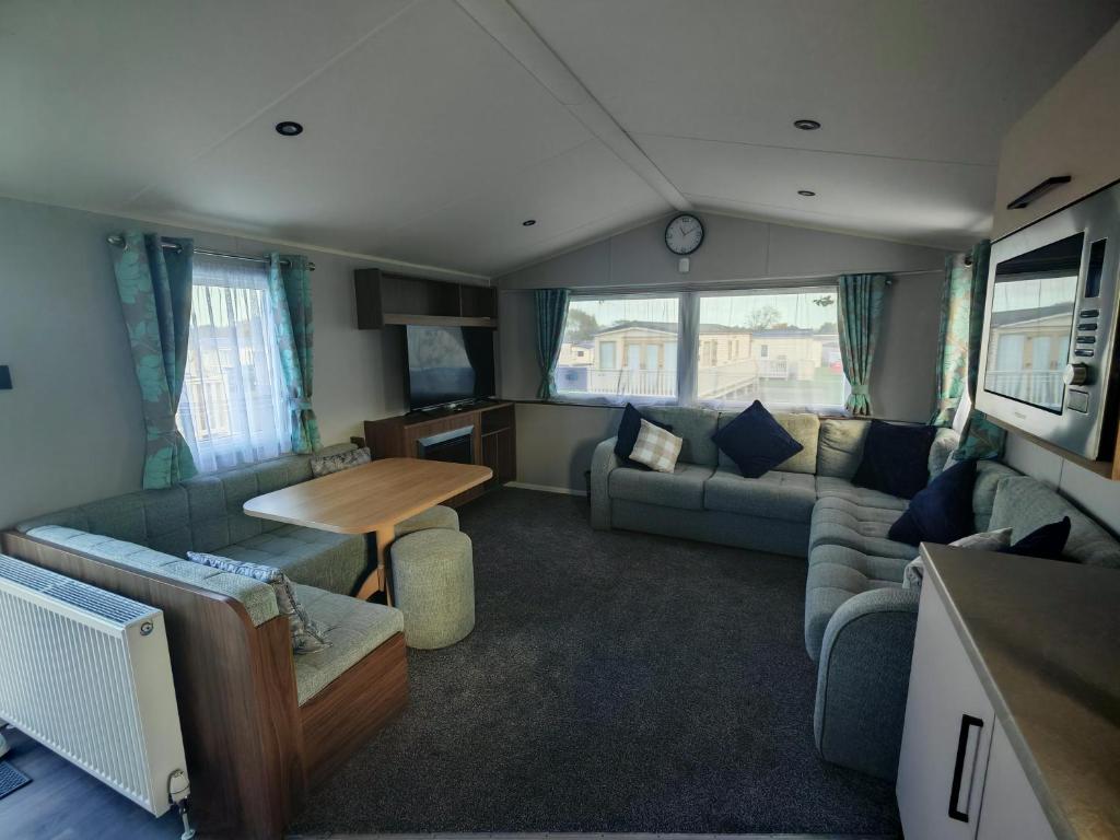 a living room with a couch and a table at Primrose Valley Primrose field 4 in Filey