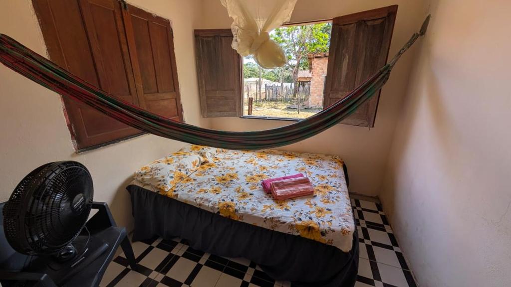 a room with a bed and a hammock at Hospedagem Tia Lene Pacoval Soure in Soure
