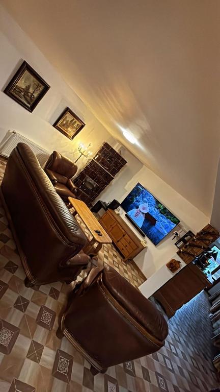 a living room with a leather chair and a table at Casa Mario 1 in Drobeta-Turnu Severin