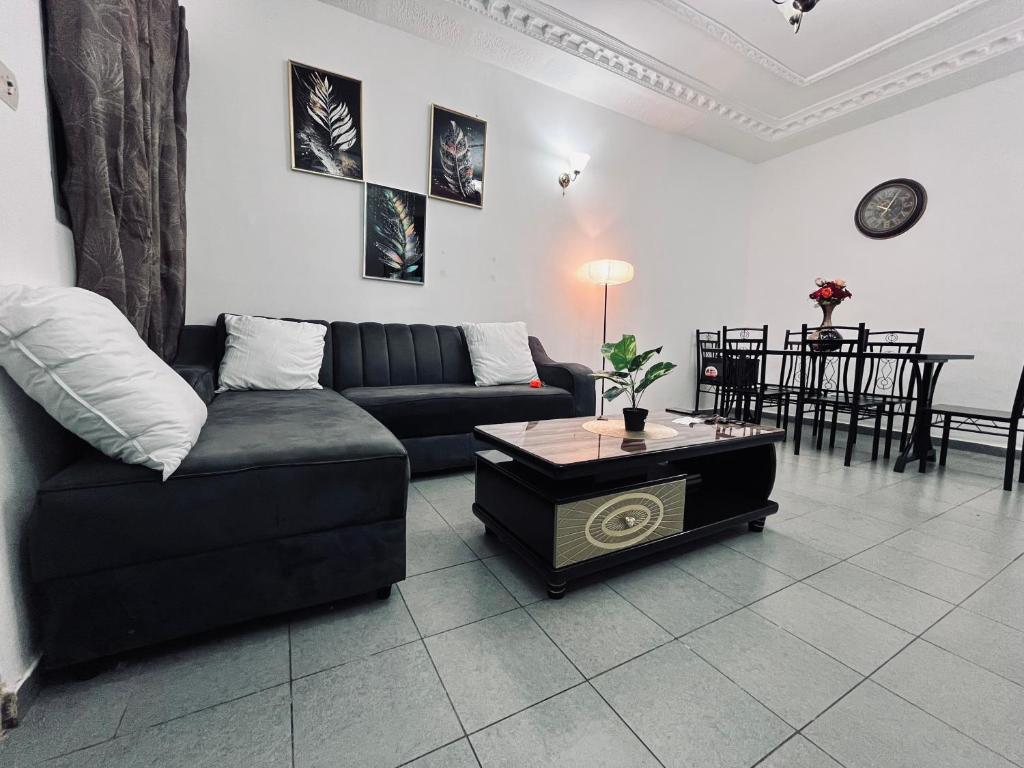 Una sala de estar con un sofá y una mesa de café. en Appartement Brel, en Yaoundé