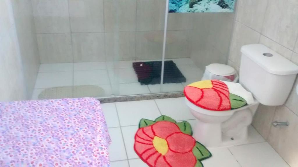 a bathroom with a shower and a toilet with pillows at Pousadinha Mangabeiras II in São Mateus