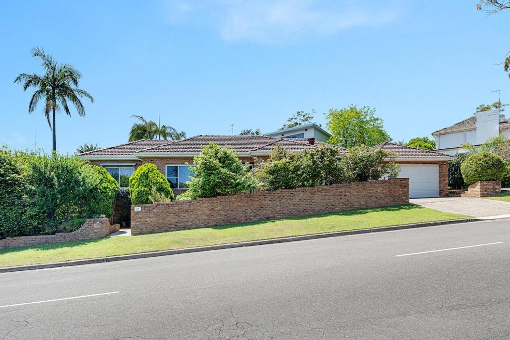 a house with a brick fence on the side of the road at Luxury 3 bedroom 2 bathroom full home with easy access near Cronulla in Lilli Pilli