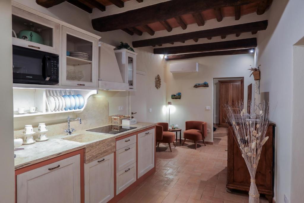 a large kitchen with white cabinets and a dining room at SweetHome San Martino in San Gimignano