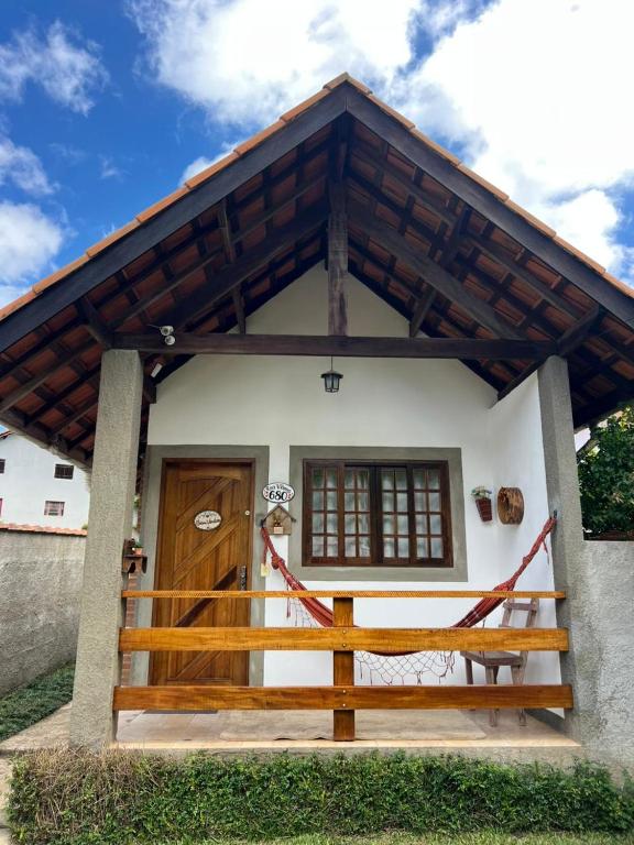 a house with a wooden door and a fence at Chalé Verde Oliva in Camanducaia