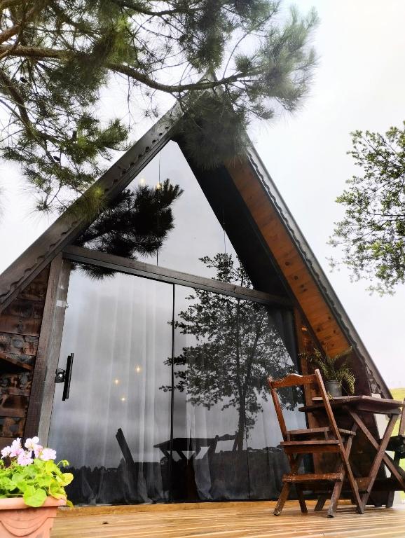 a room with a large window and a chair at Chalé do lago in Campo Alegre