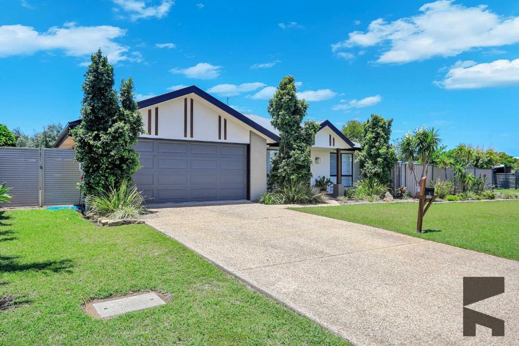 a house with a driveway and a garage at 2 Settlement Court Bargara QLD 4670 in Windermere