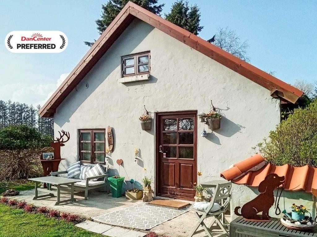 een klein wit huis met een bank en een tafel bij Tranquil Farm Annex - By Traum Ferienwohnungen in Sæby