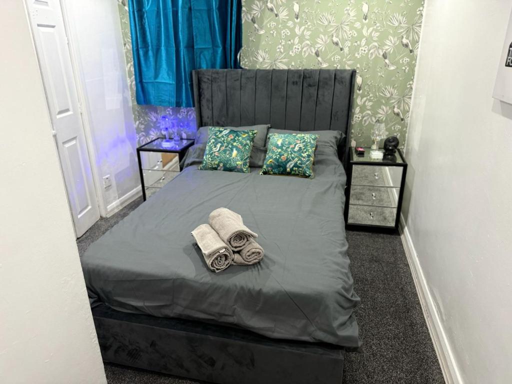 a bedroom with a bed with towels and pillows at Guest House Paradise Central in Maidstone