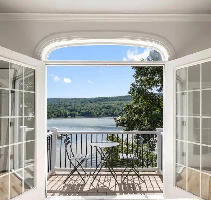Zimmer mit einem Balkon mit Tisch und Stühlen in der Unterkunft Lakeview Villa with Private Hot Tub, Firepit & Breathtaking Cliff Views in Greenwood Lake