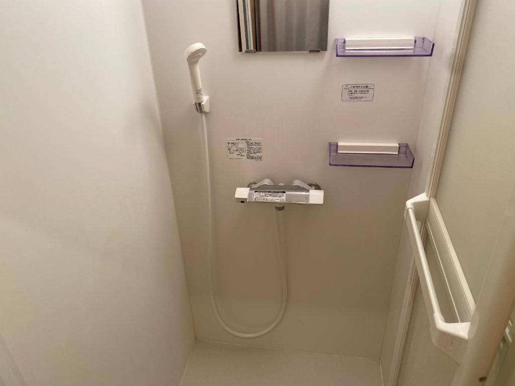 a bathroom with a shower with a sink at Takoyaki Time Osaka in Osaka