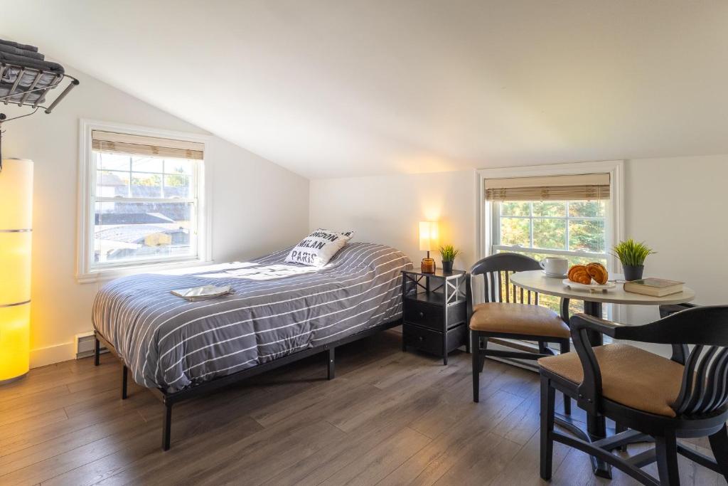 a bedroom with a bed and a table and chairs at Auberge Zacharie in Rivière-à-Pierre