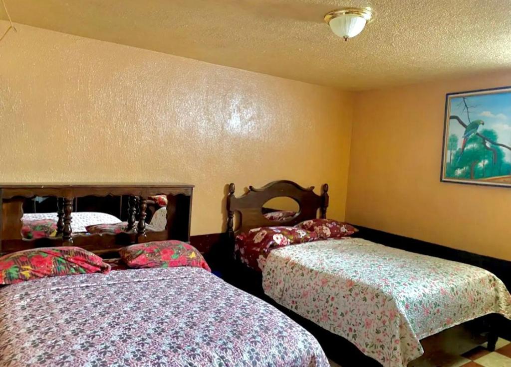 ein Schlafzimmer mit zwei Betten und einem Gemälde an der Wand in der Unterkunft Hotel Venus in Las Victorias