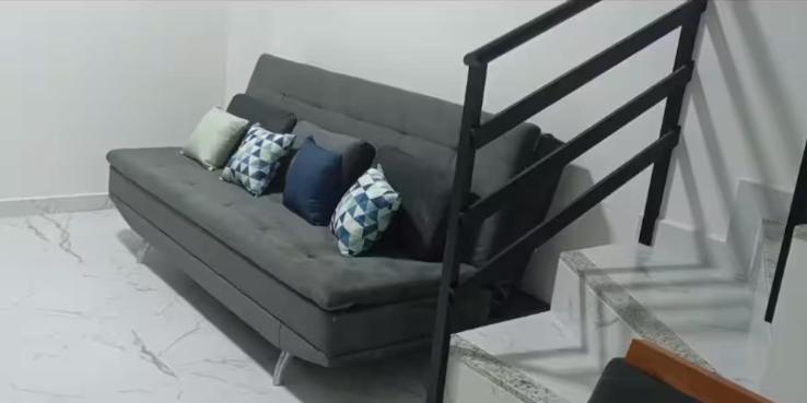 eine Couch mit Kissen darauf in einem Wohnzimmer in der Unterkunft Apartamento Praia do Sonho - Seu Refúgio Perfeito! in Palhoça