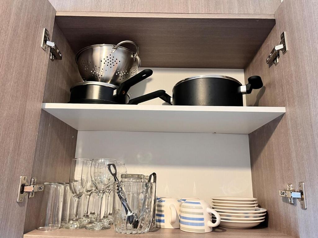 a cupboard with a pot and glasses and plates at Refugio Valdiviano - Tu descanso junto al rio in El Cerrillo