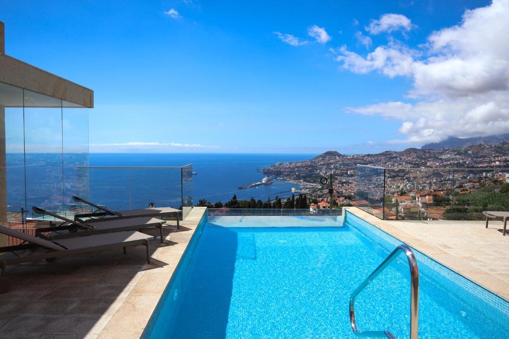 a swimming pool with a view of the ocean at FLH Funchal Bay View Escape with Pool in São Gonçalo