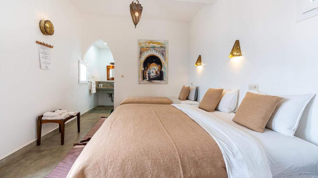 een slaapkamer met een groot bed in een kamer bij Auberge Azul Ifni in Sidi Ifni