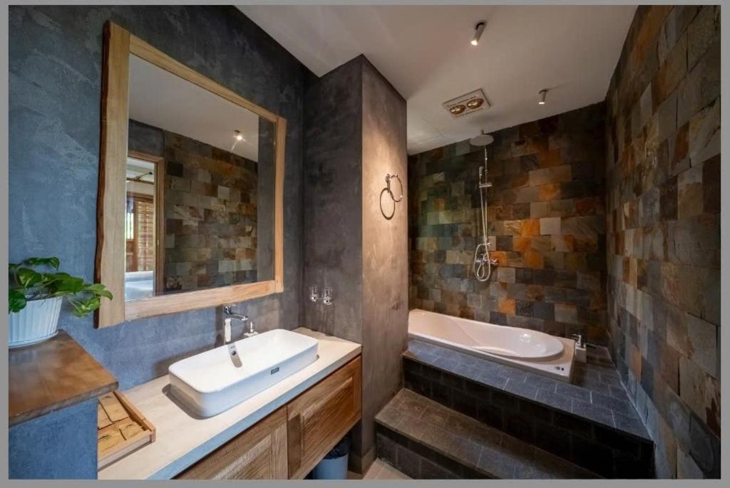 a bathroom with a sink and a bath tub at Vanlong garden in Kon Rung (1)