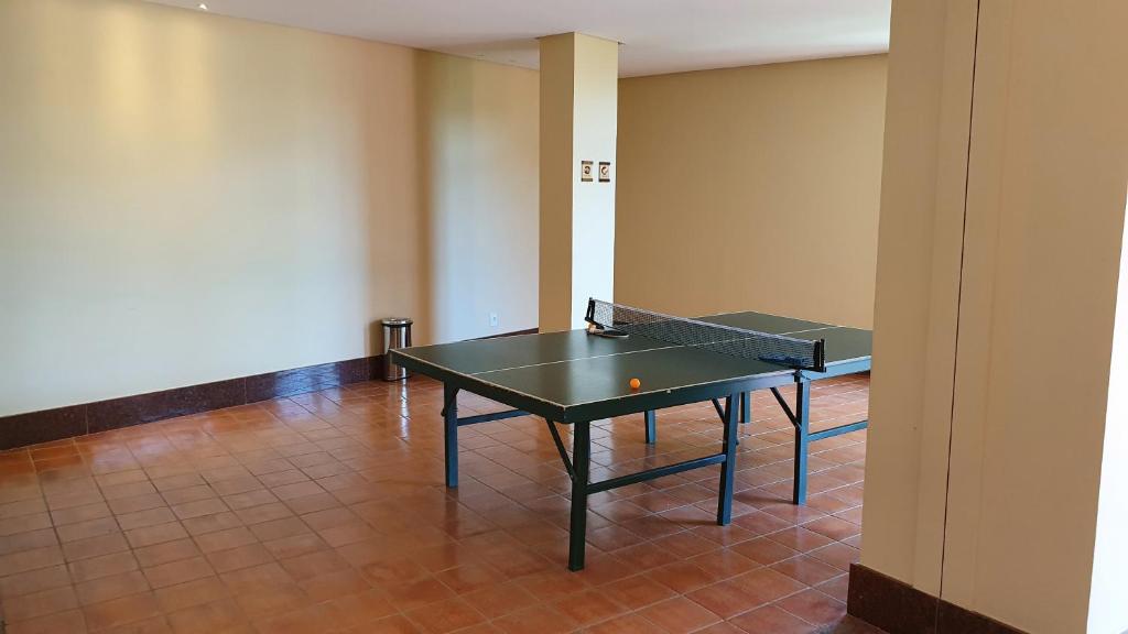 due tavoli da ping pong in una stanza vuota di Flat lindo em pedra azul a Pedra Azul