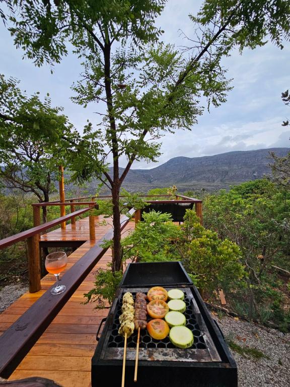 a grill with food and a glass of wine at Morada da Terra Lapinha da Serra in Santana do Riacho
