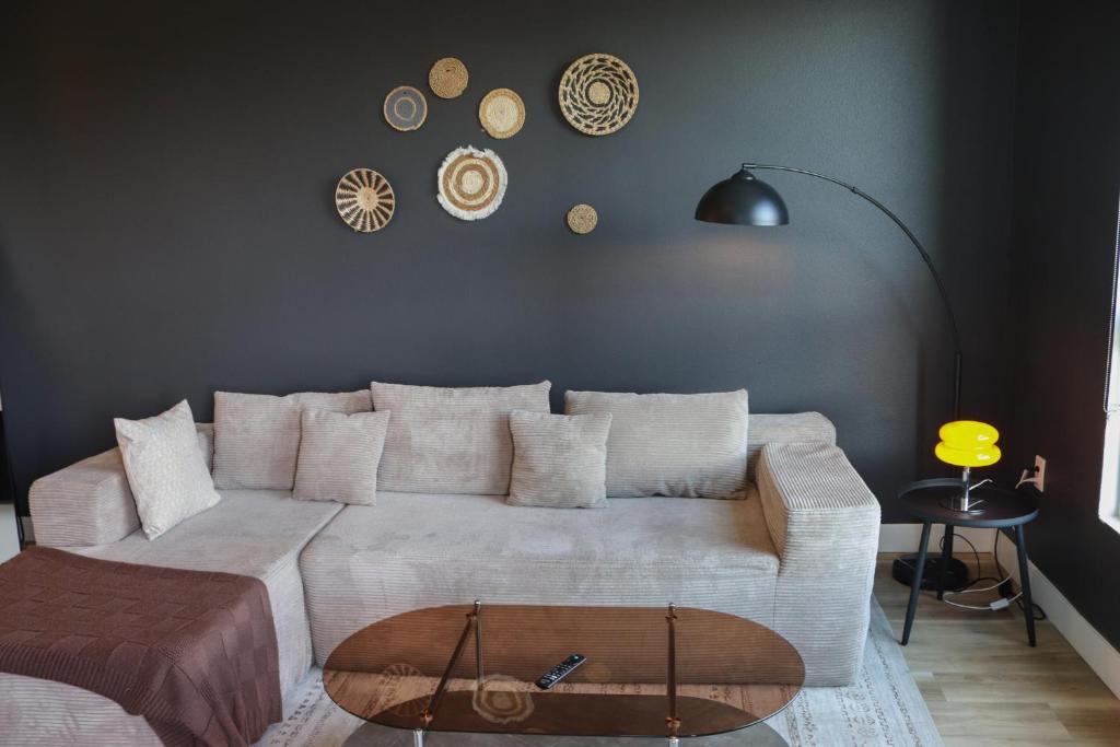 a living room with a white couch and clocks on the wall at Bright & Cozy Getaway with Pool Free Parking 10 mins Disneyland in Tustin