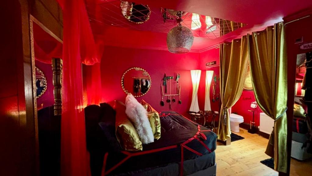 een slaapkamer met rode muren en een bed in een kamer bij Fantastic Naughty Corner in Brighton & Hove