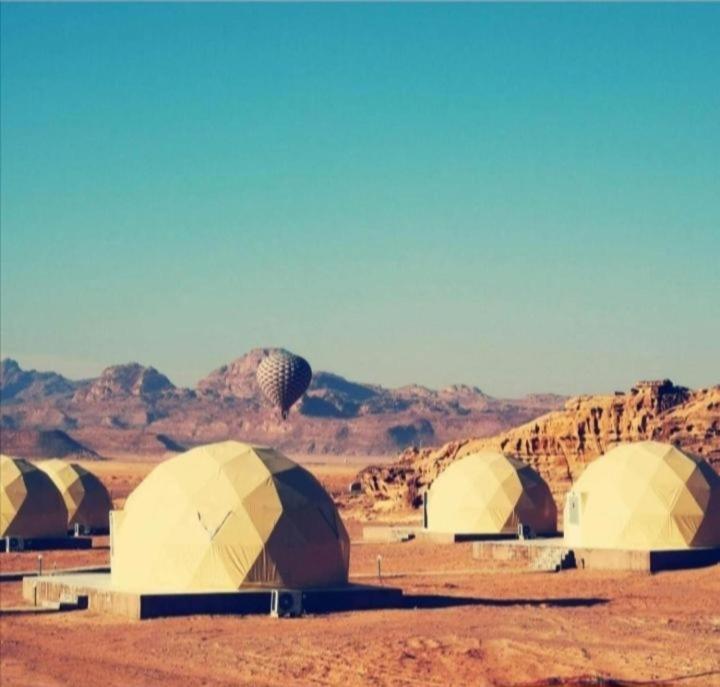 a group of domes in the middle of a desert at Rum Aranda camp & Jeep Tour in Wadi Rum
