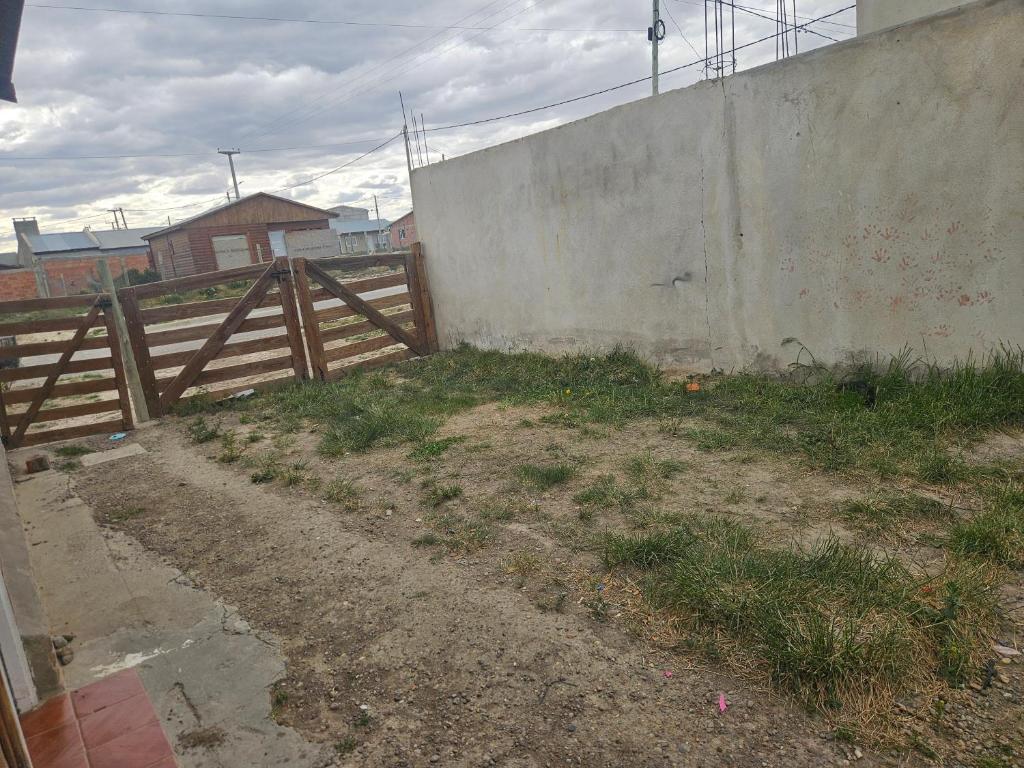 a wooden fence next to a concrete wall at Los cabos in Puerto San Julian