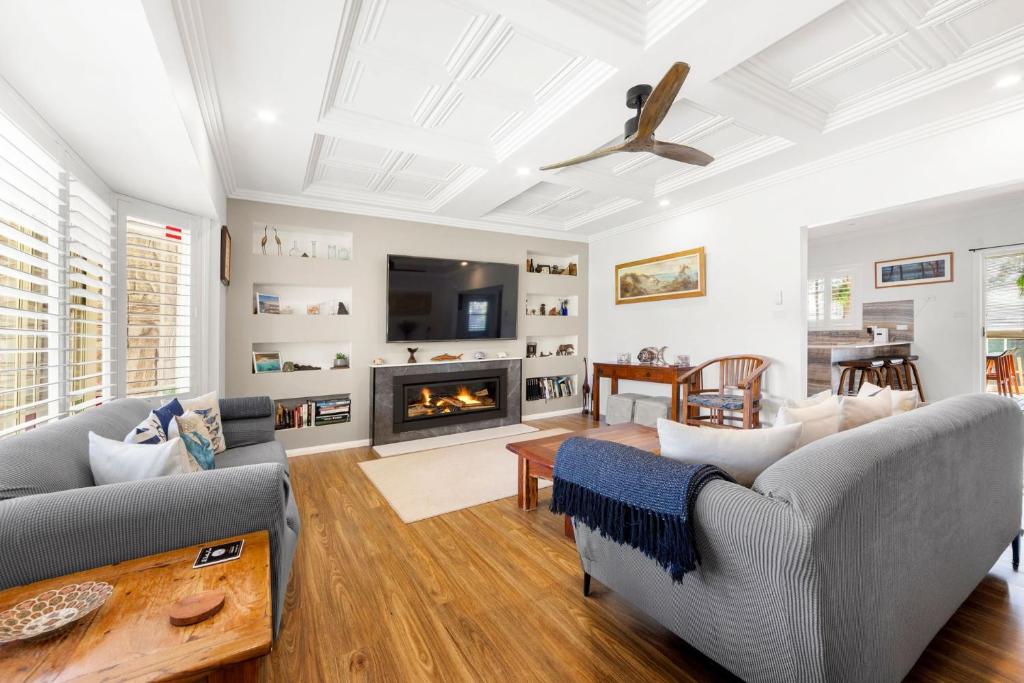 a living room with couches and a fireplace at Dolphin Cove - Pet Friendly with Fireplace in Callala Bay