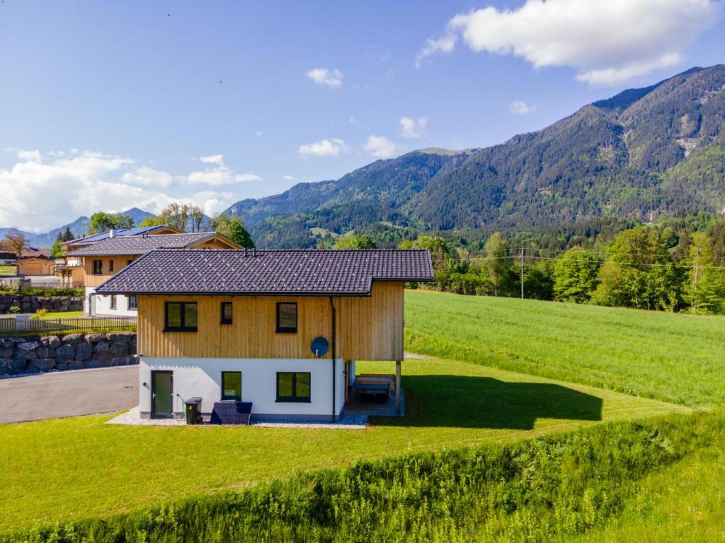 a small house in a field with mountains in the background at Obermöschach 13 in Obermöschach