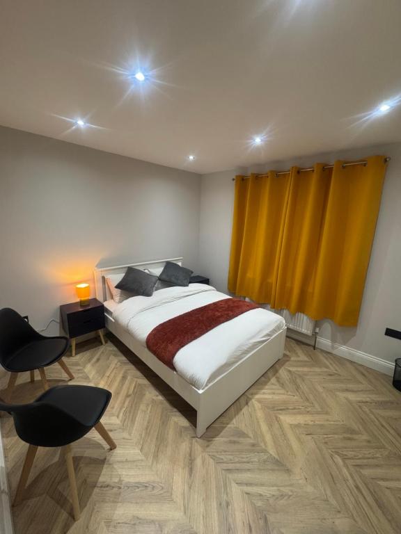 a bedroom with a bed and a yellow curtain at Richard guest house in Roydon