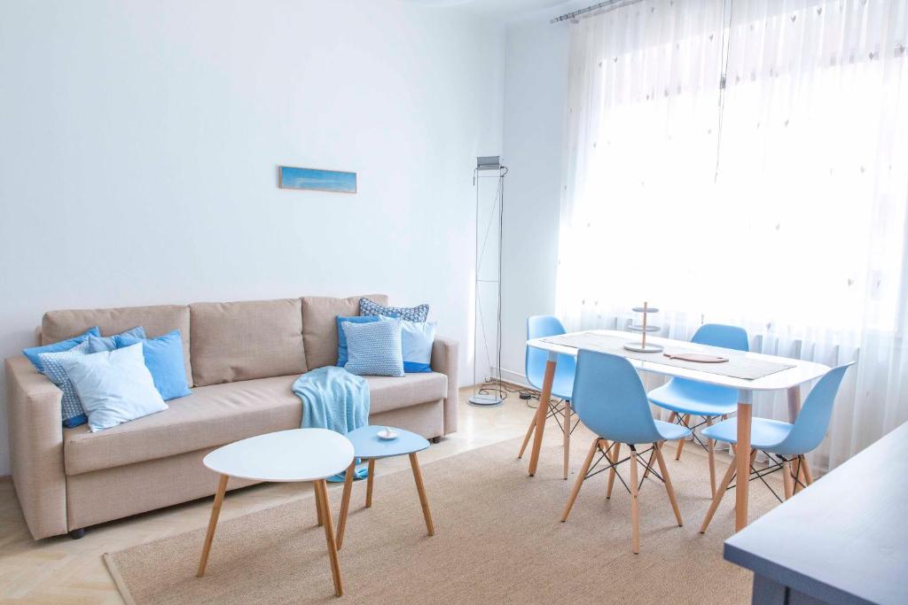 sala de estar con sofá, mesa y sillas en Taya apartment, en Liubliana