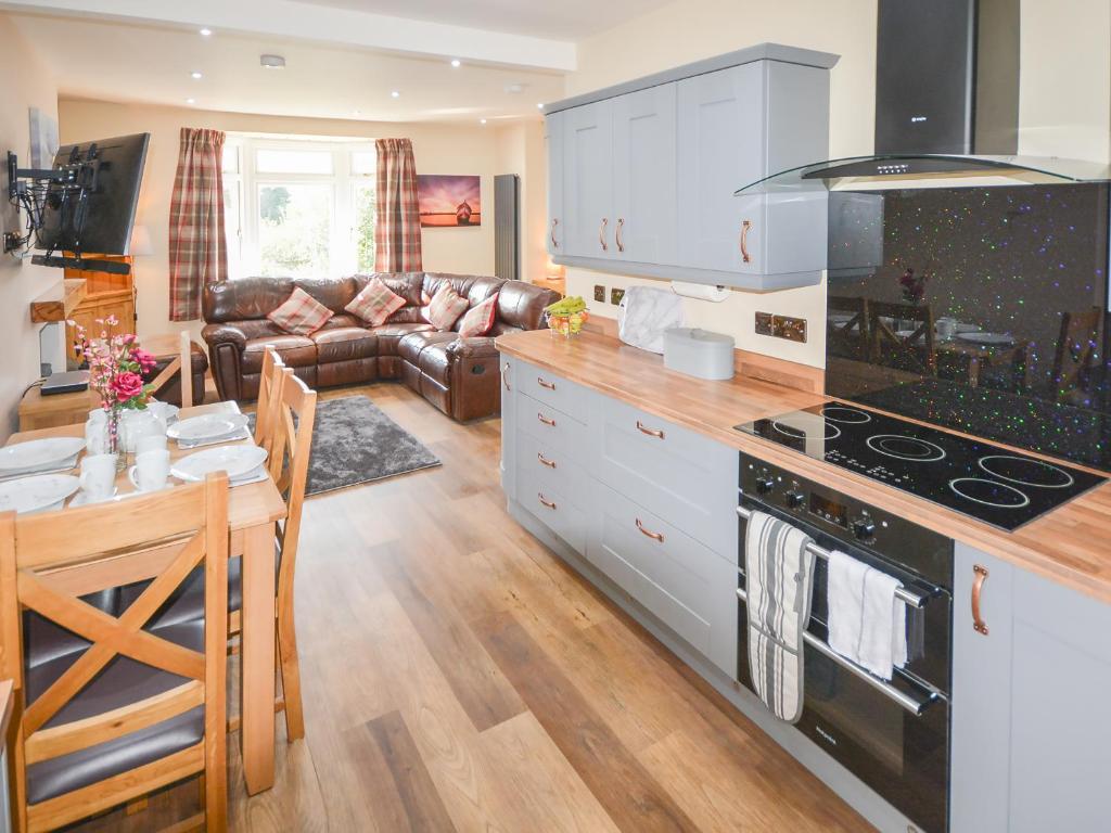 a kitchen and living room with a stove top oven at Uplands in Dalbeattie