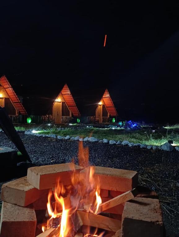 a fire pit in front of some buildings at night at Sigchos Lodge in Sigchos