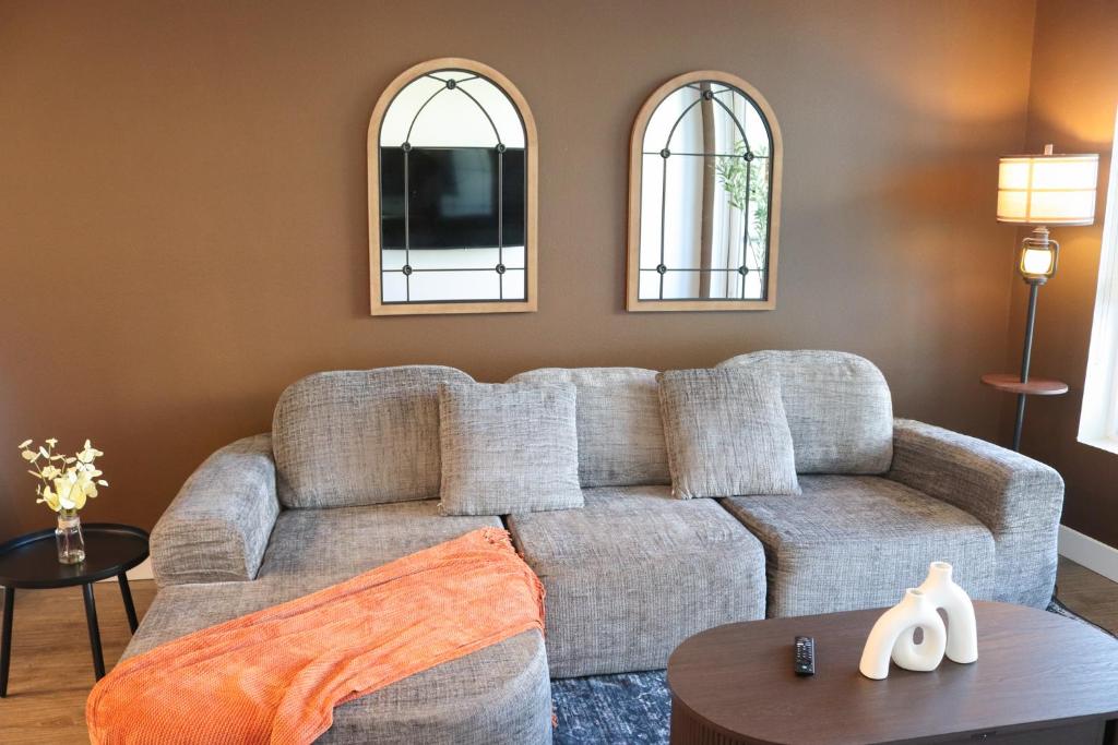 a living room with a couch and two mirrors at Resort-Style APT with Pool, Gym & Parking 10min to Disneyland in Tustin